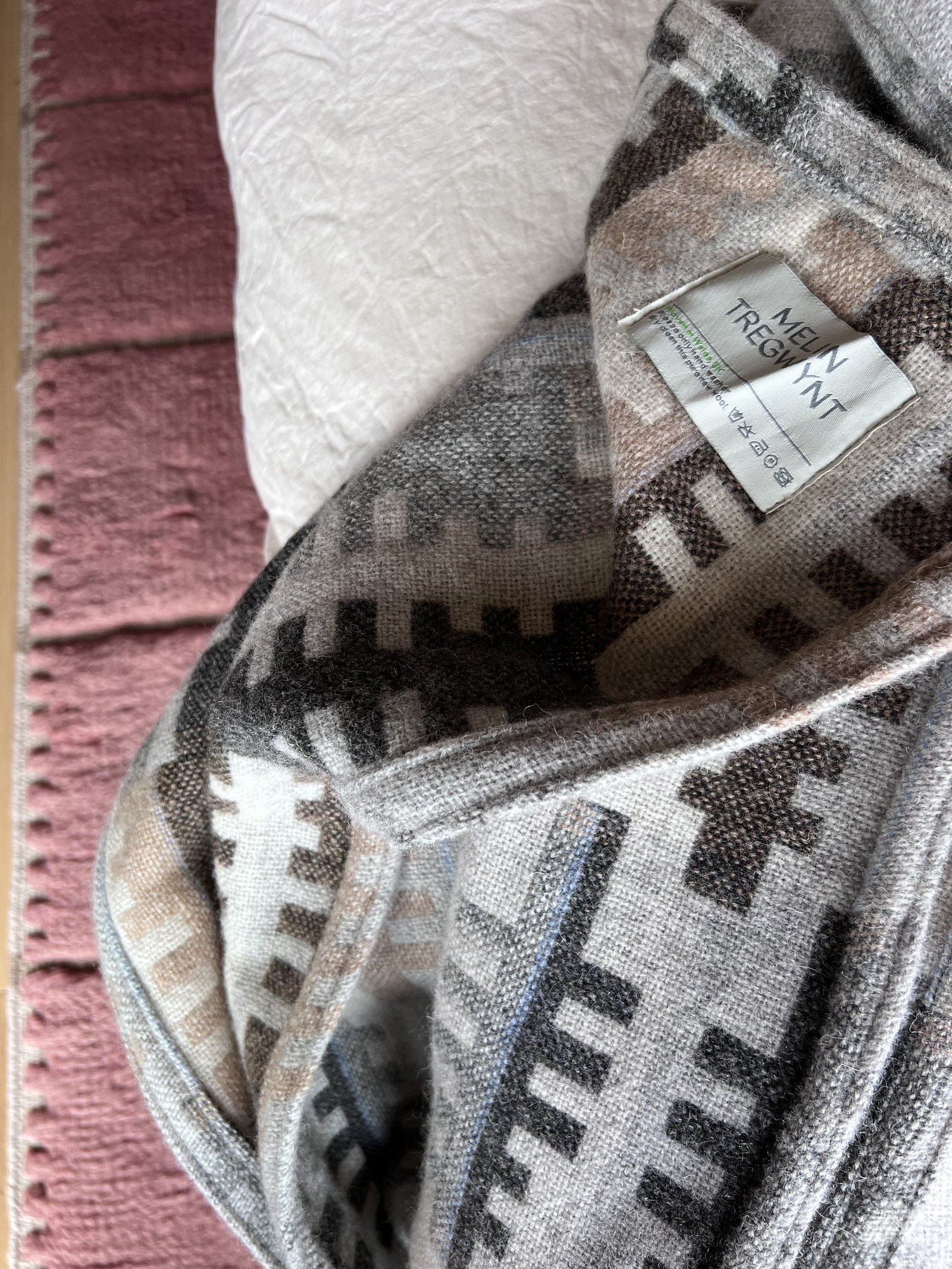 A close detail of the patterned alpine blanket with a pink bound edge