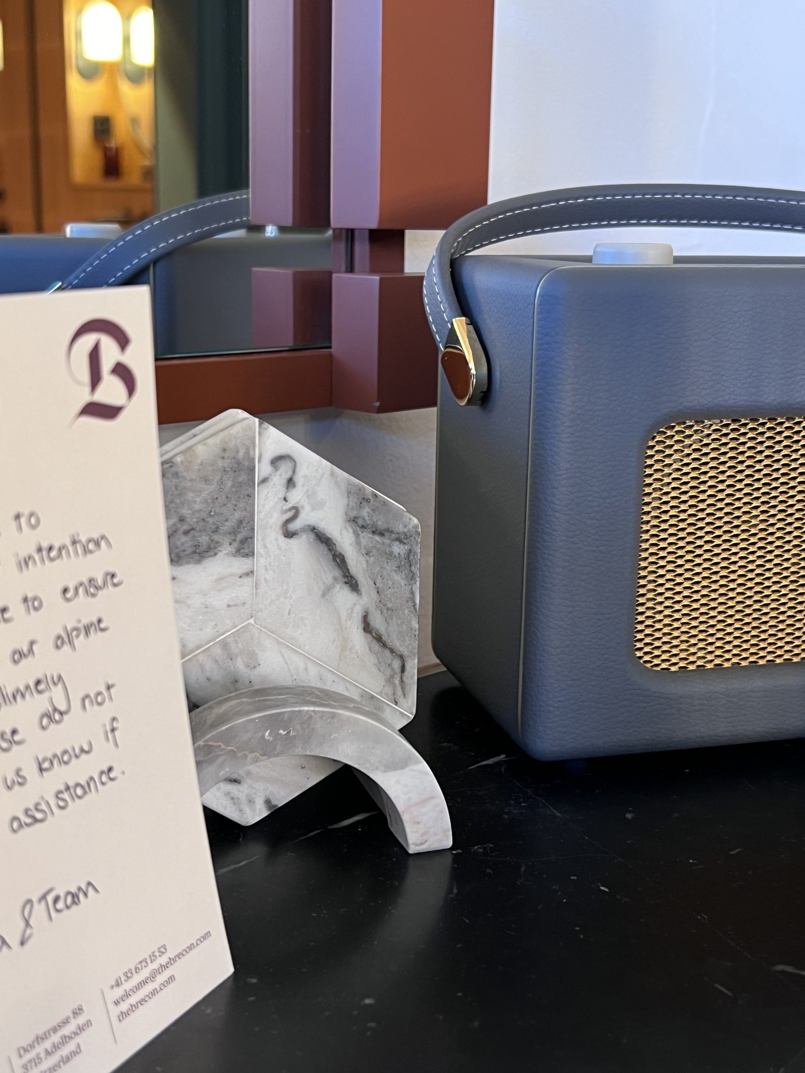 A retro blue radio on marble beside a handwritten card with a letter B printed at the top