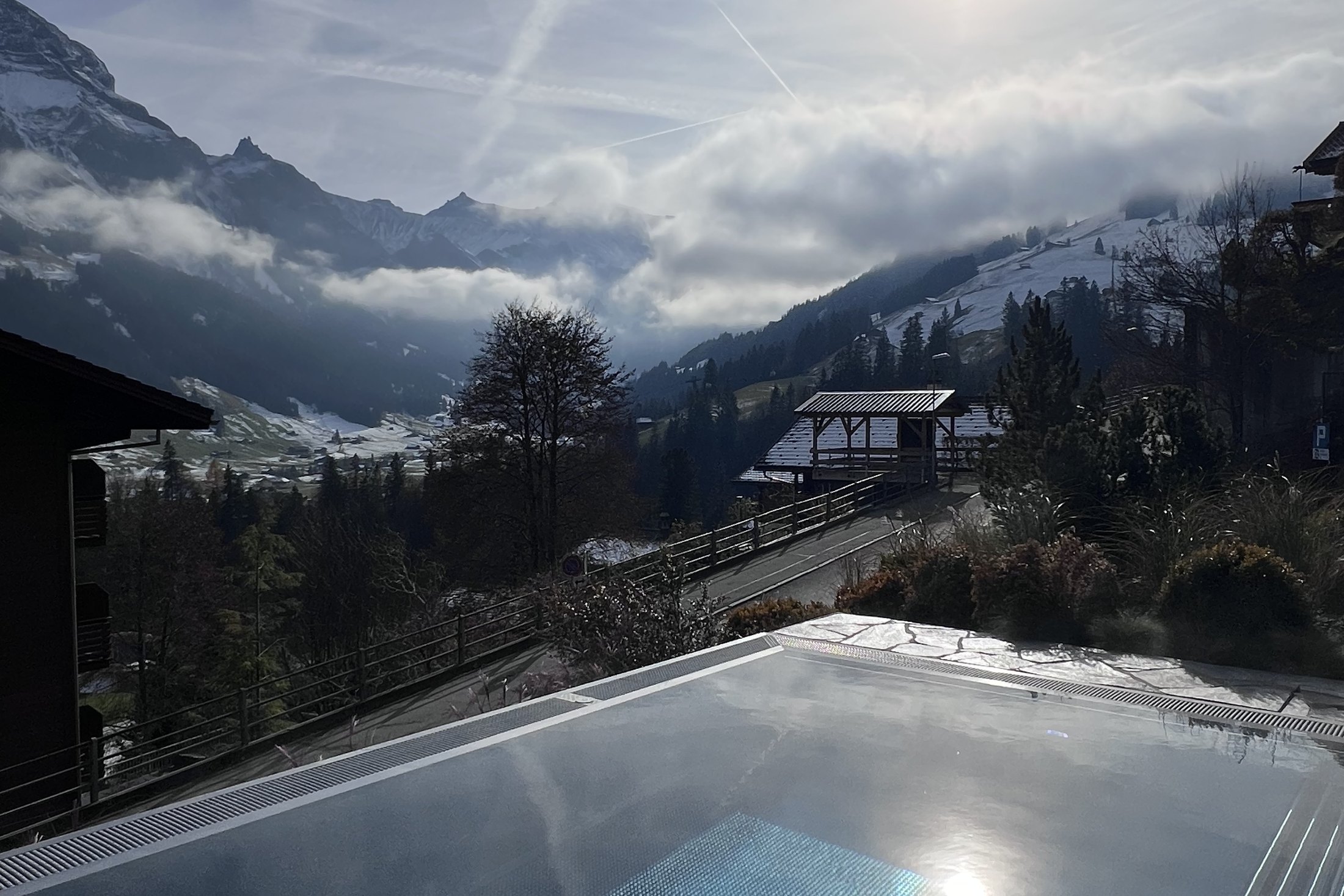 The valley at Adelboden filling with low cloud, seen over the edge of the heated outdoor pool