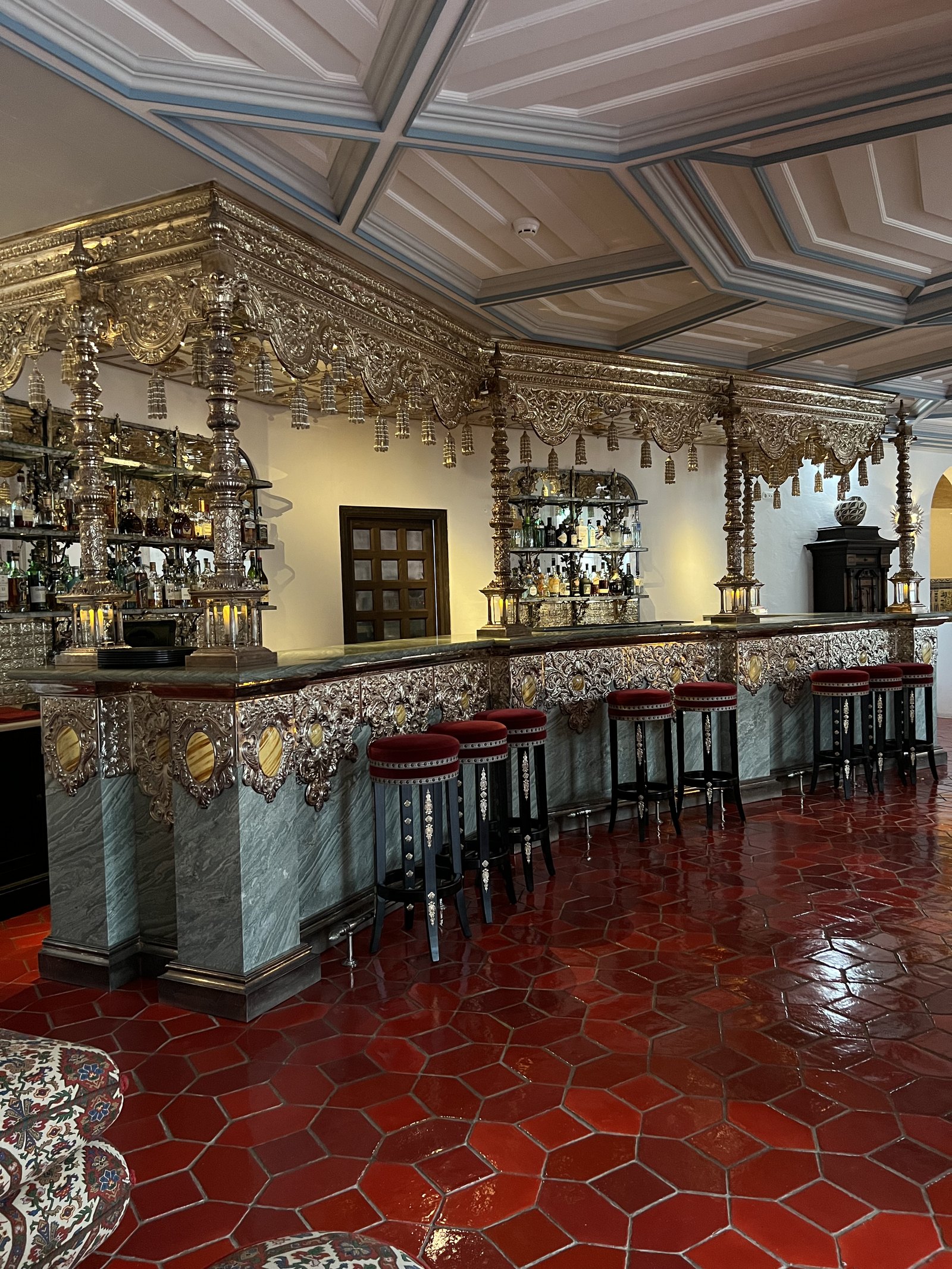 The bar at Vermelho with its hammered silver counter, tiled walls and red tiled floor