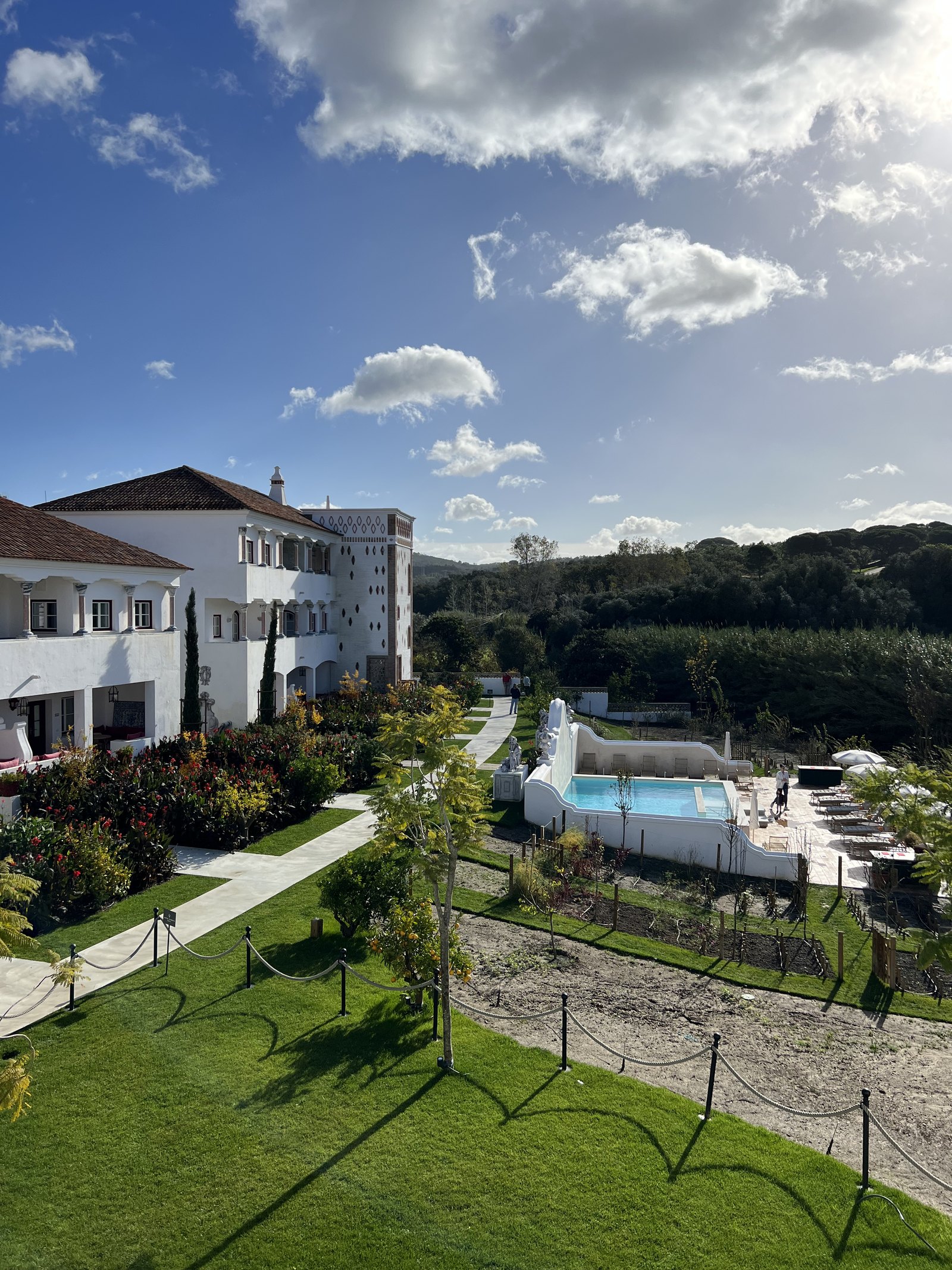The white buildings, lawns and pool of Vermelho seen from an upper terrace