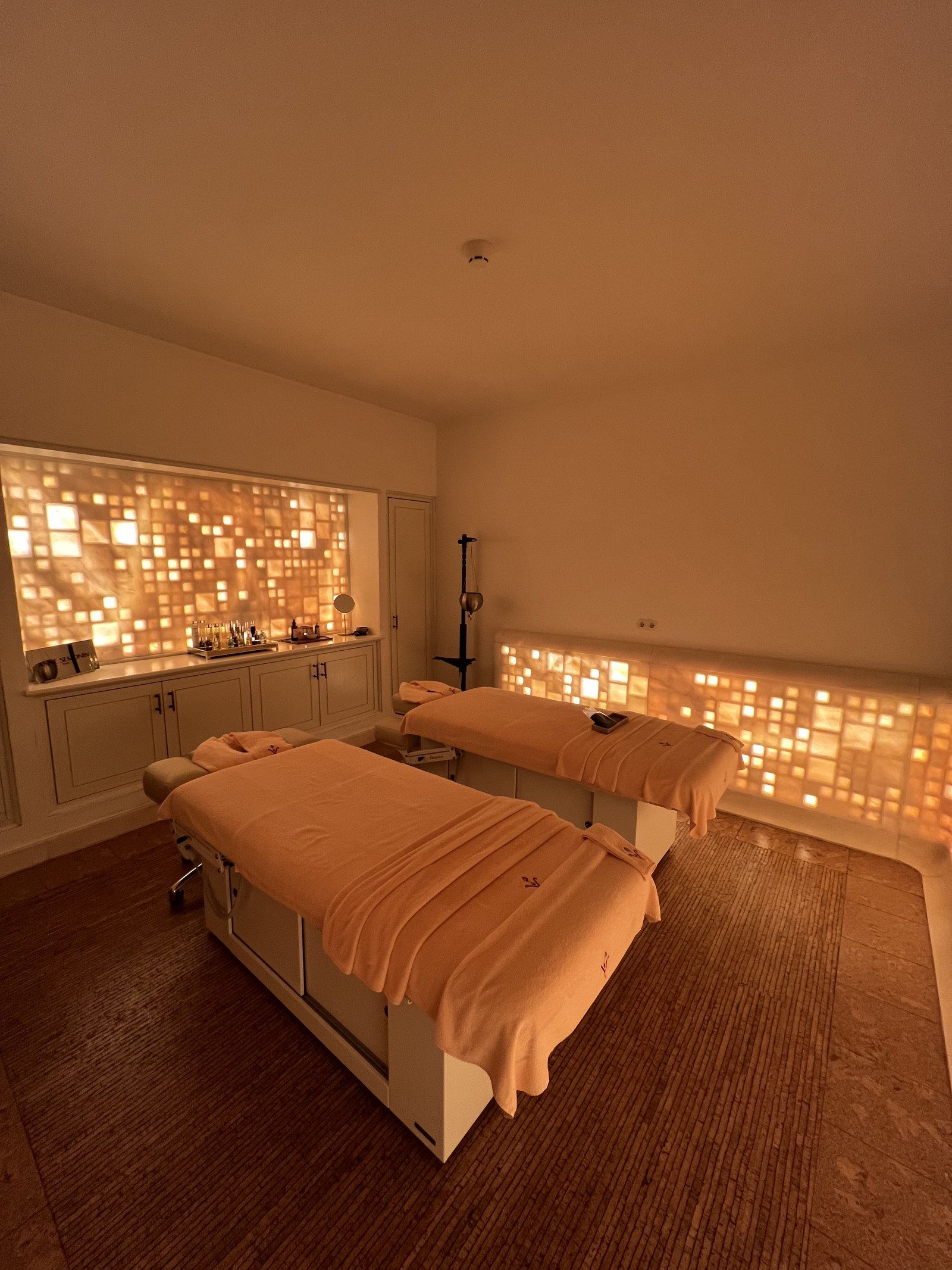 A treatment room in the spa at Vermelho with a bed and a wall of small lit panels