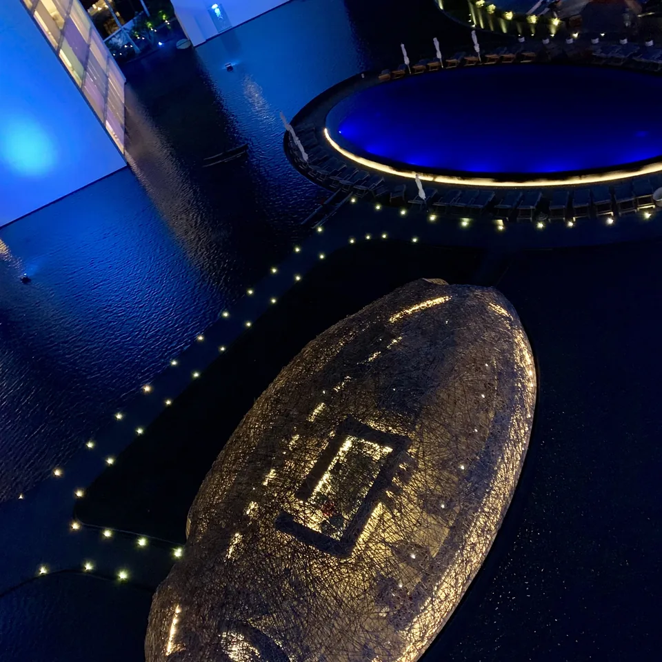 A shallow glass dish on the edge of a pool at Viceroy Los Cabos lit deep blue after dark, with small lights running along the rim