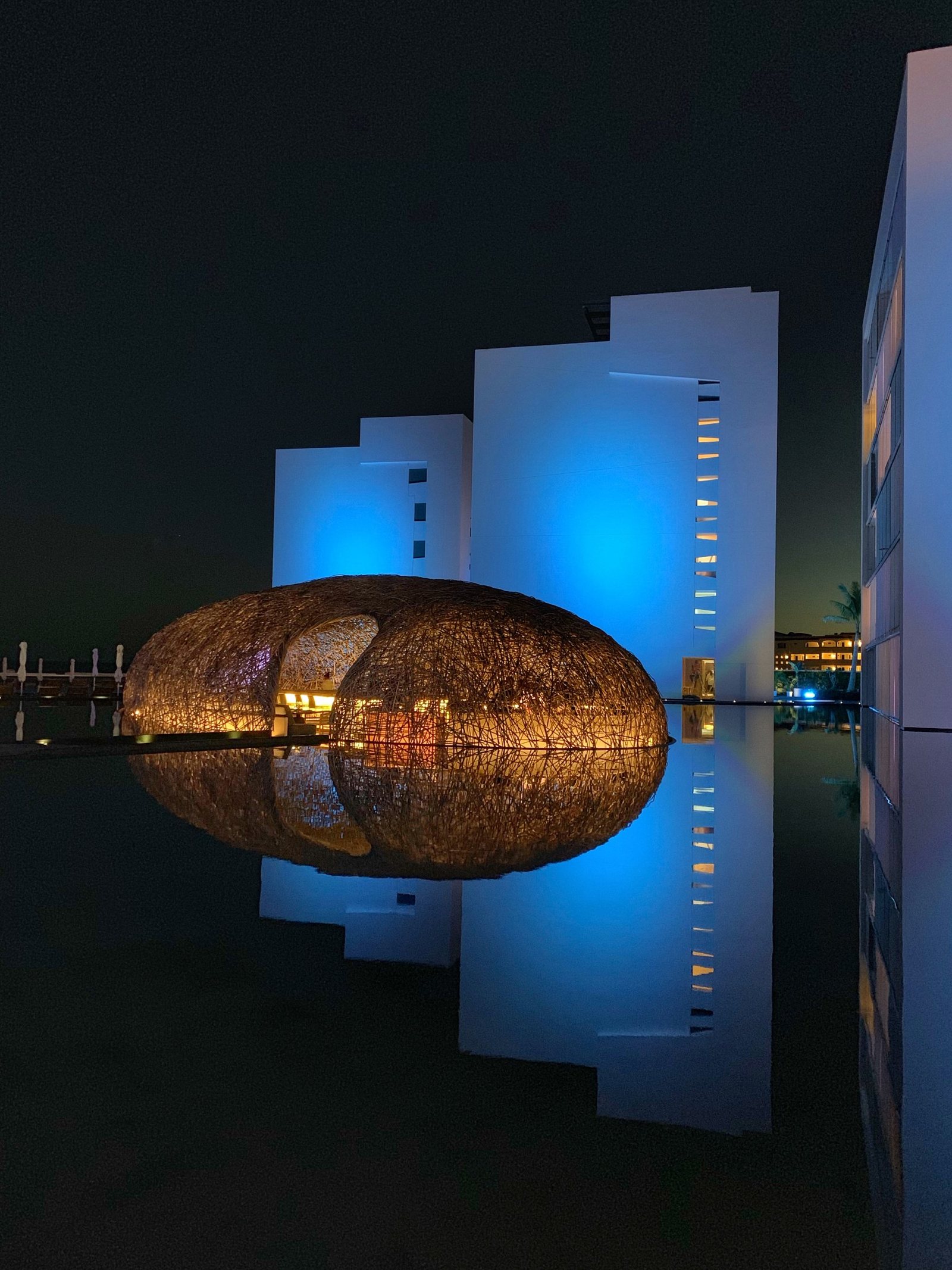 The woven nest pavilion lit over the black water at Viceroy Los Cabos, Mexico