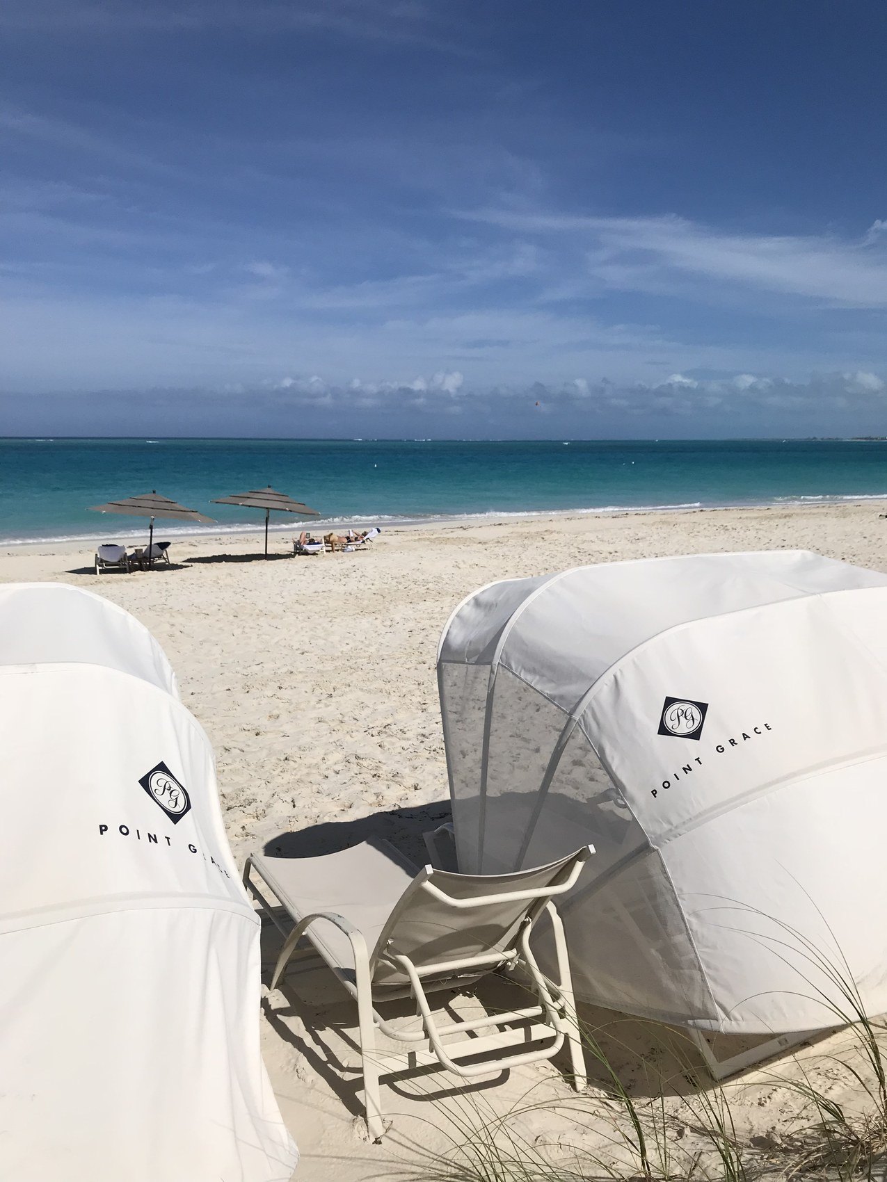 Two canvas beach cabanas open to the sand and the sea
