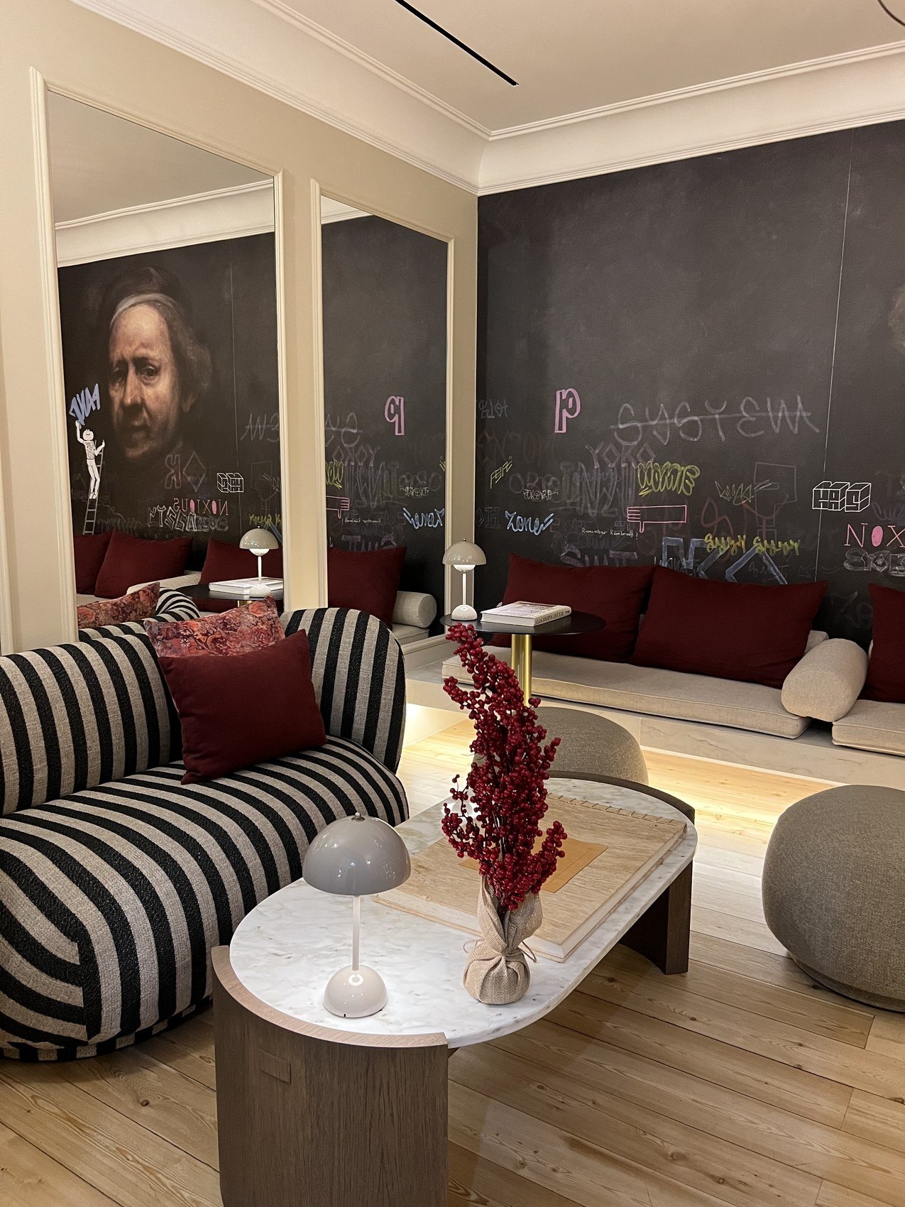 A lounge with a black and white striped sofa against walls written over in chalk