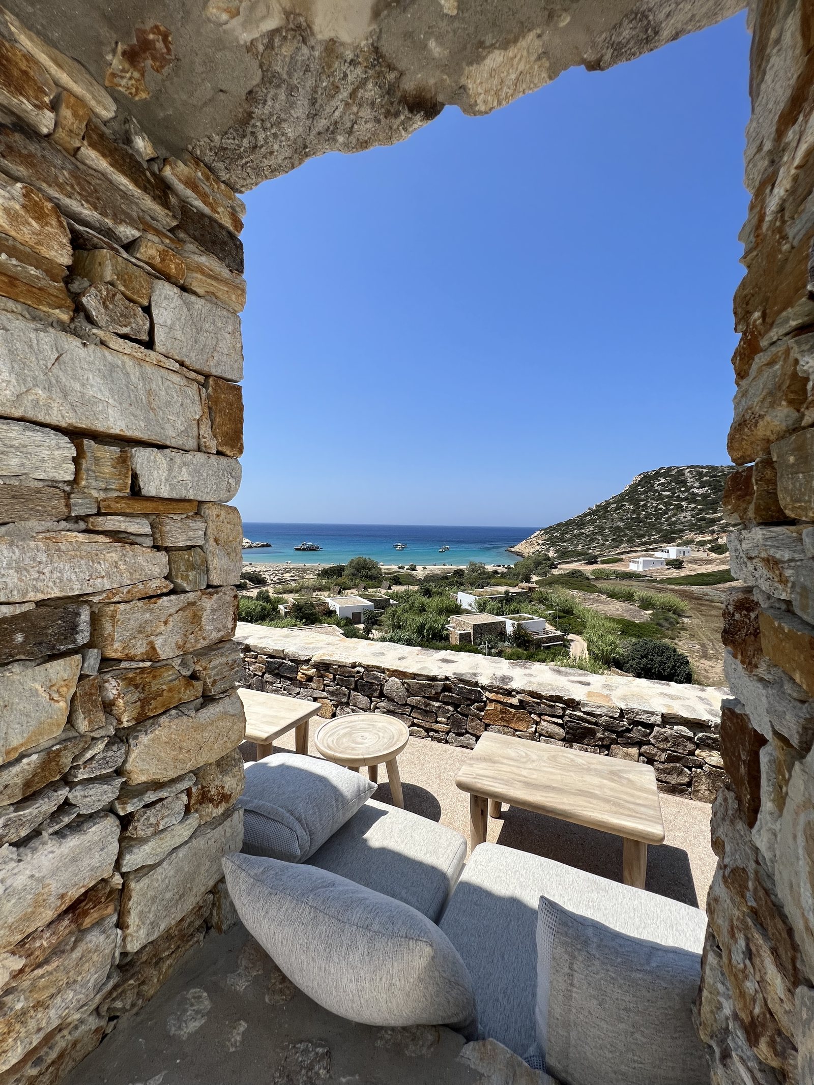 A stone opening framing a bay and the low houses above it